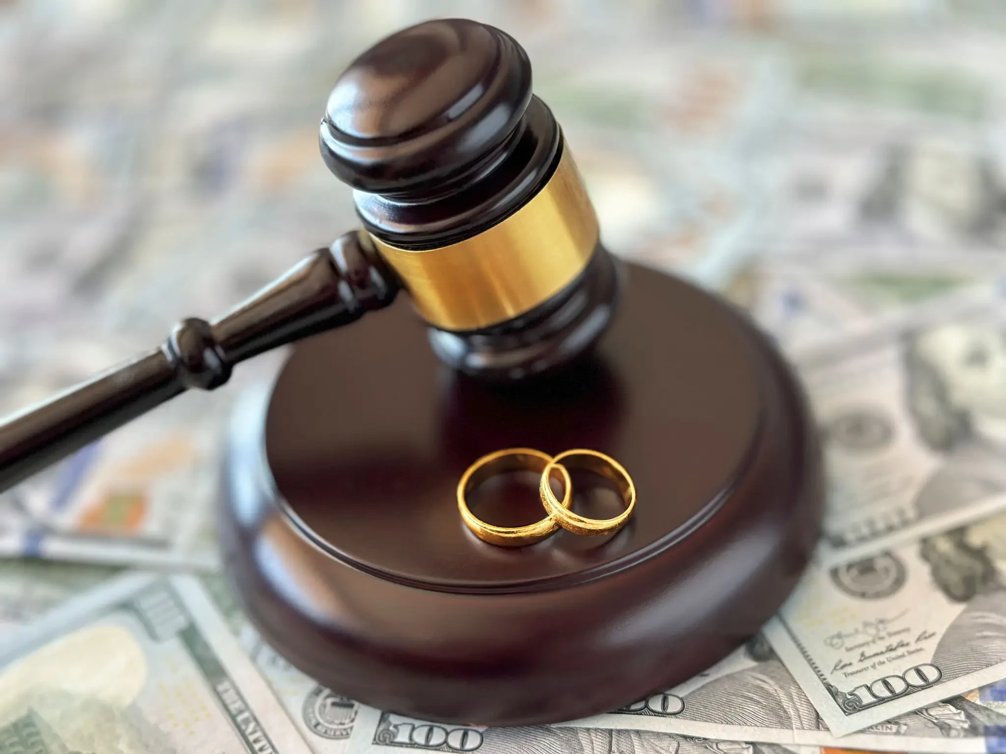 Gavel and wedding rings on money representing high-asset divorce